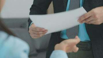 Hands of recruiter holding resume in front of candidate at desk video