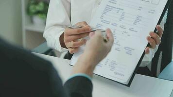 Hands of recruiter holding resume in front of candidate at desk video