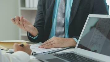 Hands of recruiter holding resume in front of candidate at desk video