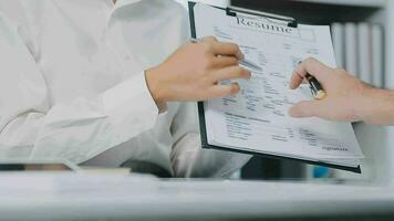 Hands of recruiter holding resume in front of candidate at desk video