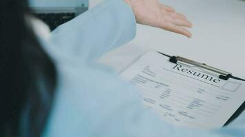 Hands of recruiter holding resume in front of candidate at desk video