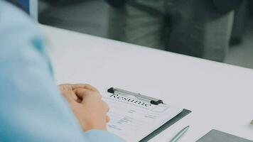 Hands of recruiter holding resume in front of candidate at desk video