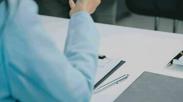 Hands of recruiter holding resume in front of candidate at desk video