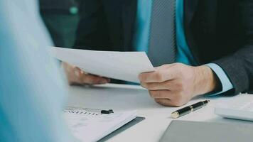 Hands of recruiter holding resume in front of candidate at desk video