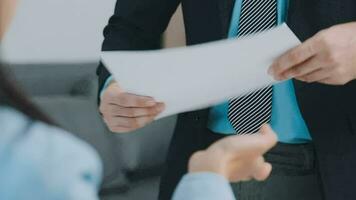 Hands of recruiter holding resume in front of candidate at desk video