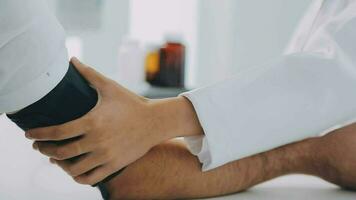 Female doctor checking old woman blood pressure at clinic and filling patient history in the morning. video