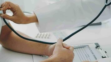 Close-up of a hand of a female doctor using a stethoscope to checking lung for a middle-aged patient who has a fever and comes to see the doctor at the health care center. video