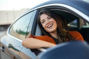 Cropped shot of an attractive young woman leaning out of a car window on a road trip photo
