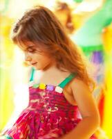 Beautiful little girl dancing over colorful background photo