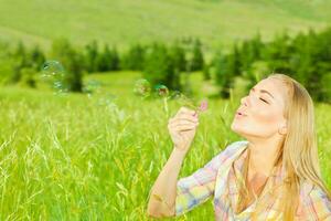 Cute girl blowing bubbles outdoors photo