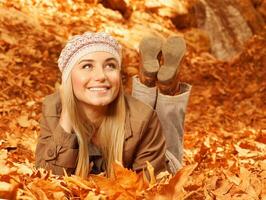 Woman lay down on autumnal foliage photo