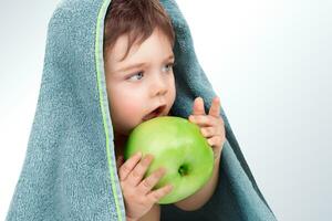 Baby boy eating apple photo