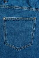 Back side and pockets of blue jeans pants close-up background photo