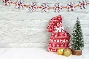 Christmas background with decorative fir tree and red gift bag. Top view, flat lay with copy space photo