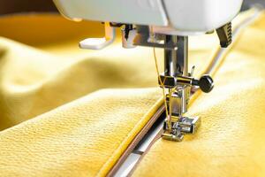 Modern sewing machine and yellow fabric. Sewing process, handmade, hobby, DIY, business, repair photo