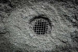 old vent hole on the background of a concrete surface photo