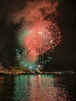 vistoso fuegos artificiales en el noche cielo en el paseo marítimo de alicante España foto