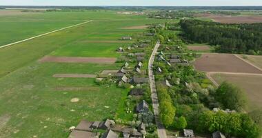 panoramic aerial view and flight over eco village with wooden houses, gravel road, gardens and orchards video