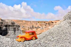 un juguete coche se sienta en parte superior de un montaña foto