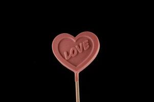 a heart lollipop with the word love written on it photo