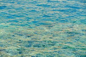 el agua es claro y azul con algunos rocas foto