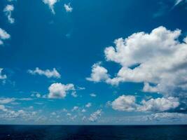 un azul cielo con nubes terminado el Oceano foto