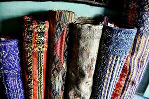 a row of colorful rugs are lined up on a wall photo