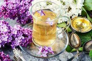 Cup of tea and lilac flowers photo