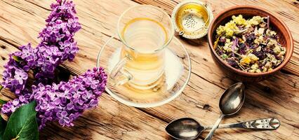 Cup of tea and lilac flowers photo