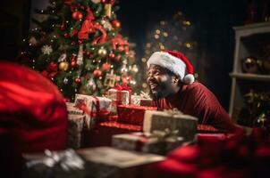 A black man in a santa hat sits near a Christmas tree in a mountain of gifts. Generative AI photo