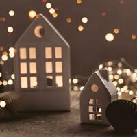 Christmas background with white ceramic house and paper ballon a background. Christmas background with garland lights bokeh photo