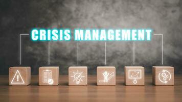 Crisis management concept, Wooden block on desk with crisis management icon on virtual screen. photo