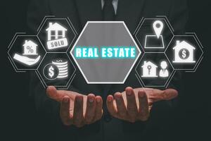 Real estate concept, Businessman hand holding real estate icon on virtual screen, Home sales and home insurance, Property insurance and security. photo