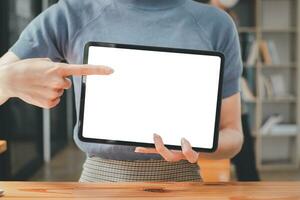 Front view of a business woman working in the office, pointing at the screen, office worker using digital tablet. photo