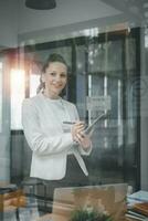 Female business woman standing and analyzing the business report in the office. photo