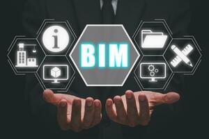 BIM, Building Information Modeling Technology concept, Businesman hand holding Building Information Modeling icon on virtual screen, Industry construction, Architect designer. photo