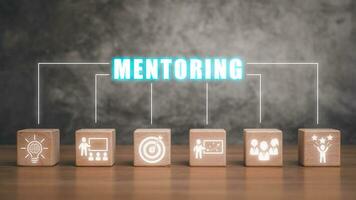 Mentoring concept, Wooden block on desk with mentoring icon on virtual screen. photo