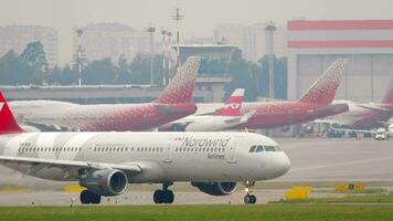 MOSCOW, RUSSIAN FEDERATION JULY 30, 2021 Commercial jet plane Airbus A321 of Nordwind taxiing. Airliner on the taxiway. Row of planes at the terminal. Busy Sheremetyevo airport, airfield video