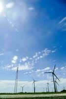 wind turbines in a field with a blue sky photo