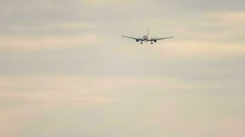 Jet plane approaching landing at sunset. Passenger flight arrival. Aircraft flying video