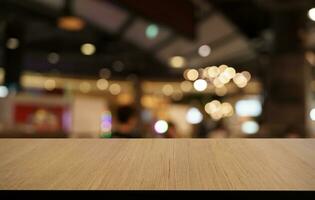 Mock up for space. Empty dark wooden table in front of abstract blurred bokeh background of restaurant . can be used for display or montage your product photo