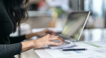 Working by using a laptop computer on wooden table. Hands typing on a keyboard.technology e-commerce concept photo