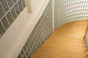 Glass blocks on the wall and wood floor. Wooden staircase and glass wall, interior design. photo