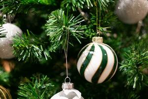 Closeup of ball hanging from a decorated Christmas tree. Close up of balls on Christmas tree. New Year concept. photo