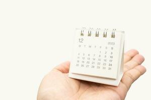 Simple desk calendar for December 2023 on palm isolated on white background. Calendar concept with copy space. photo