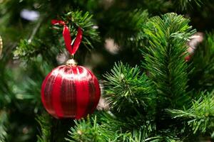 de cerca de pelota colgando desde un decorado Navidad árbol. cerca arriba de pelotas en Navidad árbol. nuevo año concepto. foto