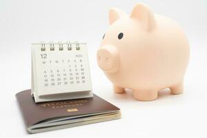 Travel planning and budget concept. Calendar, Passport, and piggy bank to collecting money for vacation trip. Preparing for vacation. photo