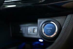 Blue power ignition button to start keyless ignition hybrid car engine Power button on a vehicle. photo