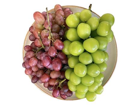 isolated plate with red and green grapes It is a fruit that is popular to eat fresh because it has high nutritional value. and processed into various products such as grape juice and wine. photo