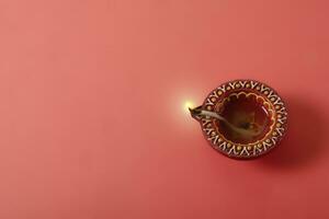 Happy Diwali and Kartika Deepam Festival Greetings - Colorful clay diya lamps on red background photo